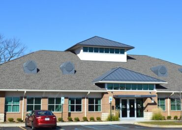 Modern medical facility building with clear blue sky.