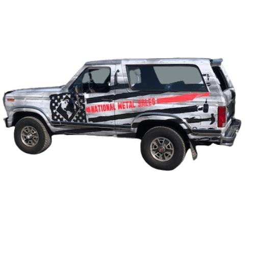 Side view of a silver off-road vehicle with a roof rack and decals.